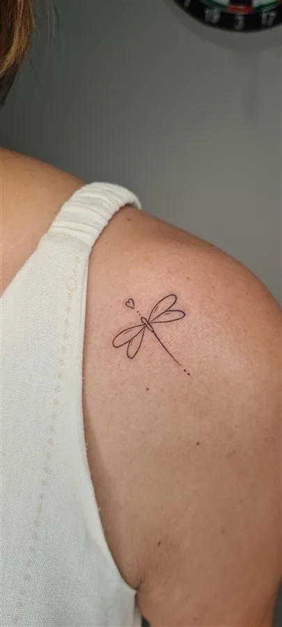 Tatuagem fine line de libélula no ombro